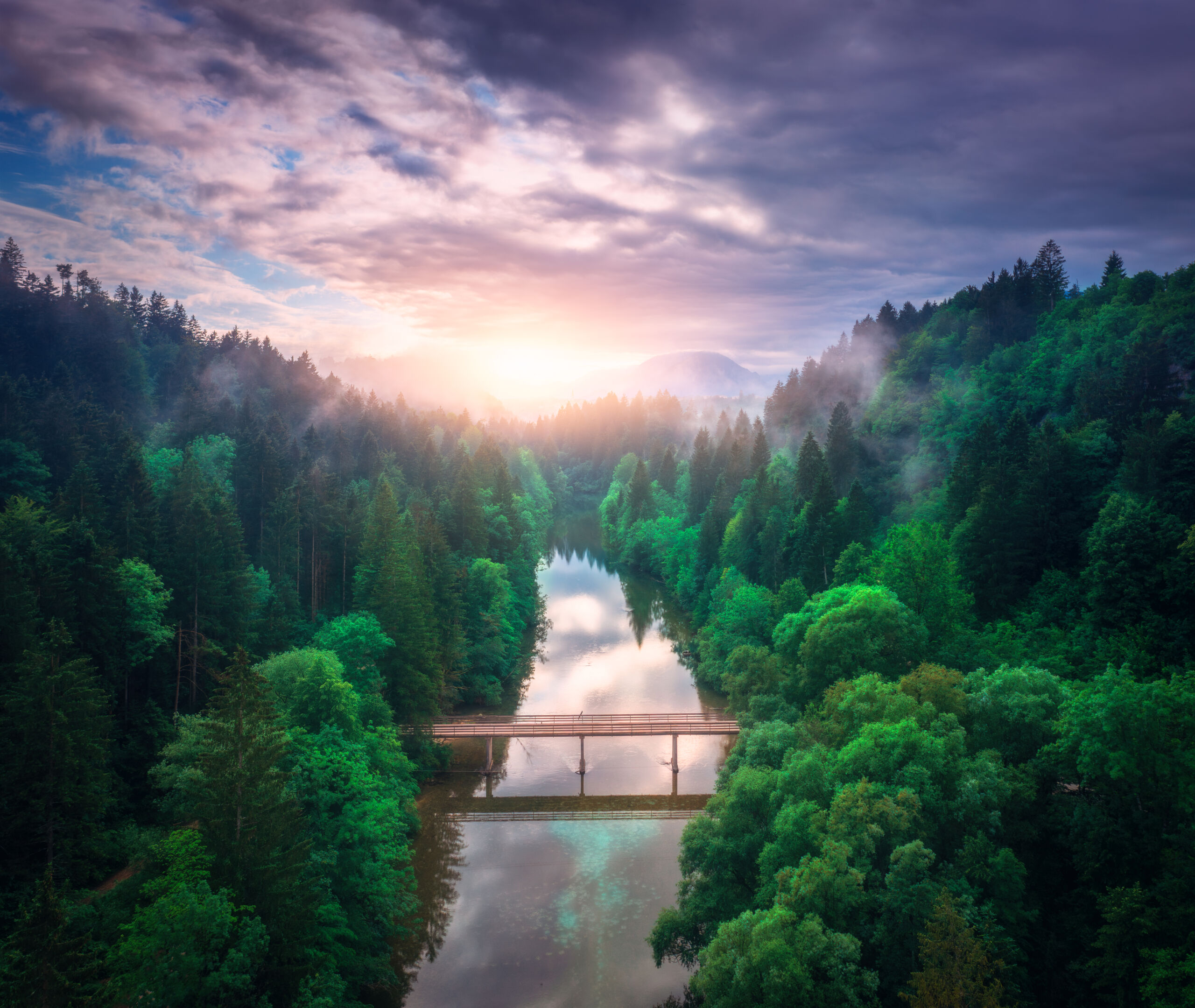 Aerial view of wooden bridge over the river in mountains